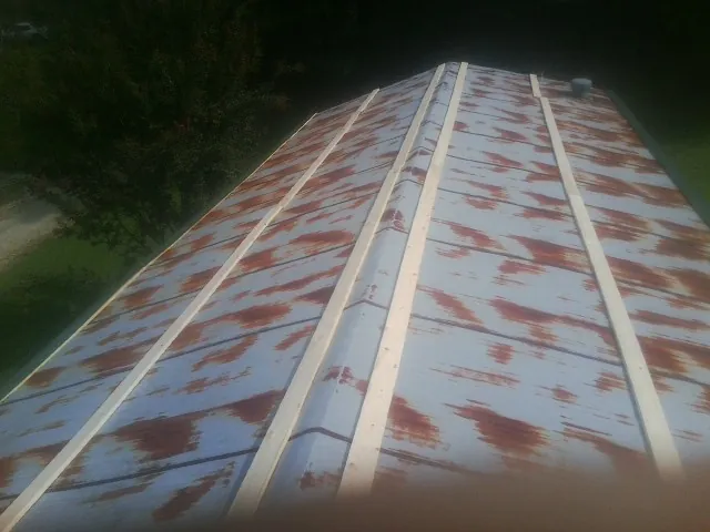 Rusted metal roof panels with new wood purlins before replacement — Storm Damage Roof Repair in Willow Hill by Roofing Brothers