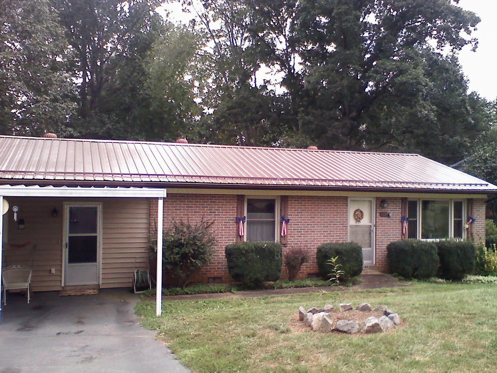 Bronze metal roof and carport on a brick ranch home — Roof Repair work by our crew in Willow Hill